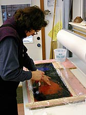 Nancy Current siliconing glass in her studio.